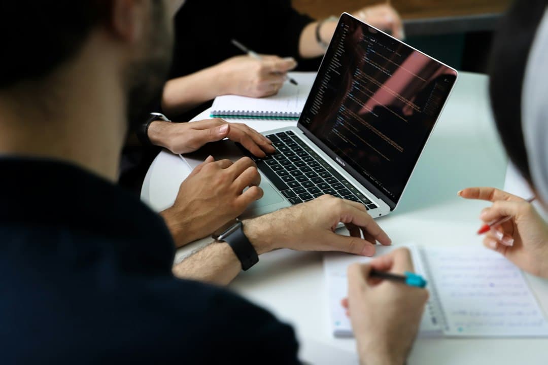 Business team reviewing work together around a laptop