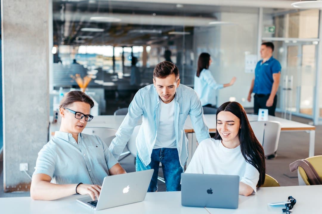 Marketing team reviewing analytics on laptops around a table