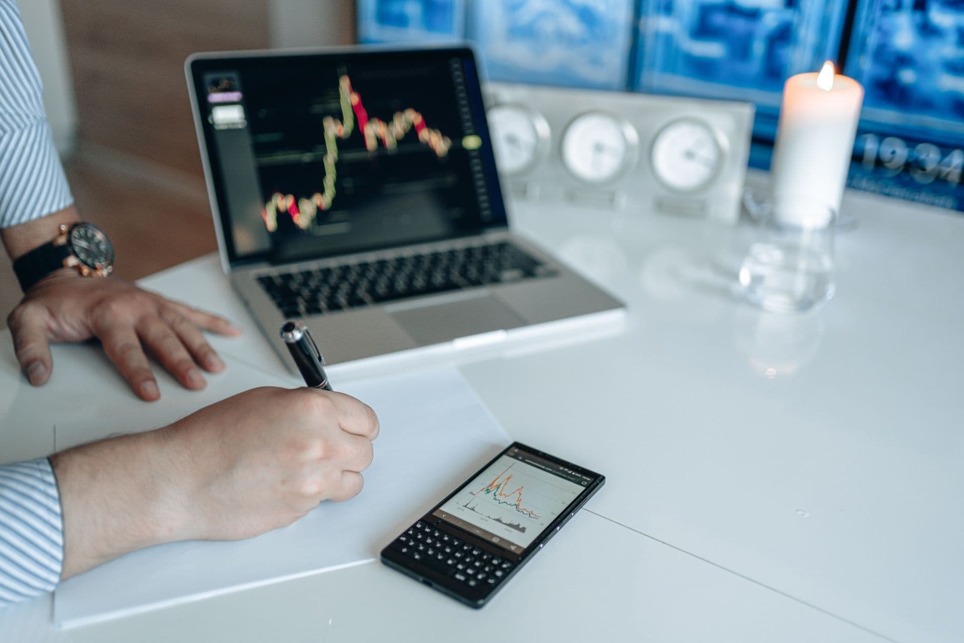 Person reviewing trend graphs and notes beside a laptop